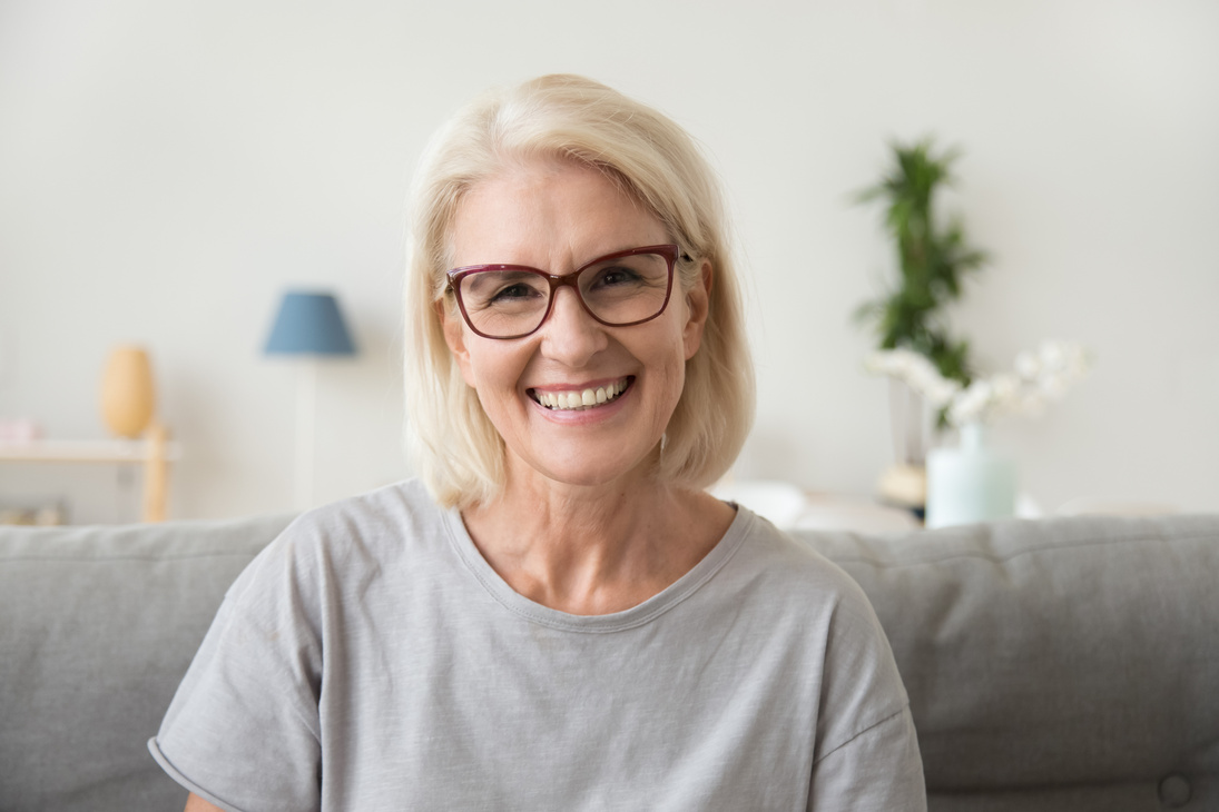 Smiling middle aged mature grey haired woman looking at camera